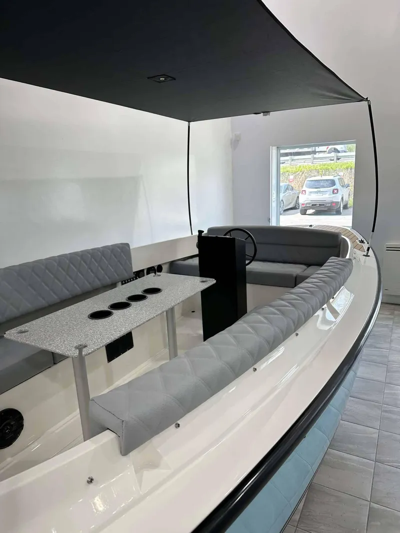 Slide: The Image of 2023 Vision Marine Technologies Fantail 217 boat interior with seating and table under canopy. - 2