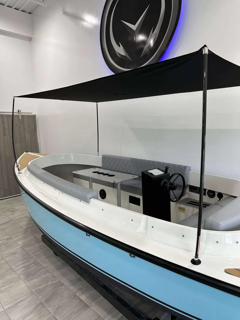 Slide: The Image of 2023 Vision Marine Technologies Fantail 217 boat with canopy, displayed indoors. - 3