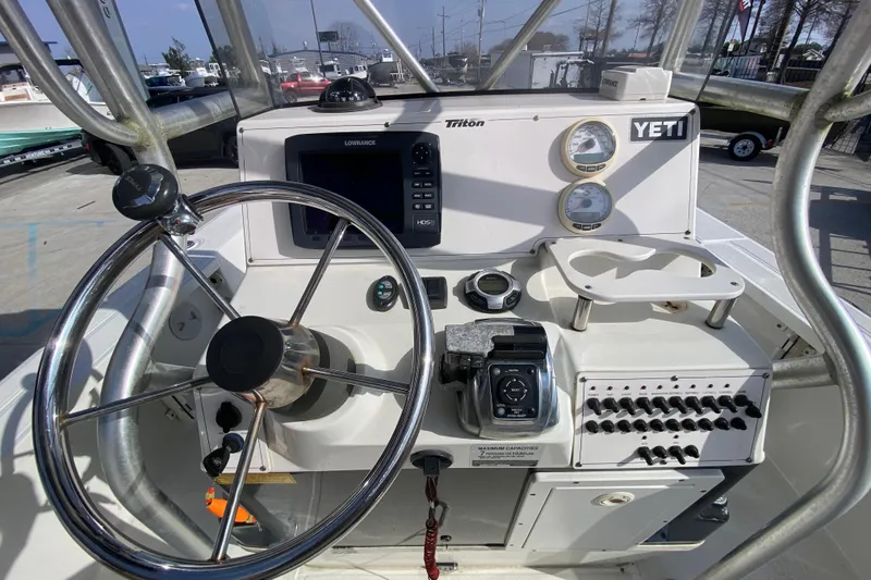 Slide: The Image of 2007 Triton 240 LTS boat console with steering wheel, gauges, and navigation equipment. - 10