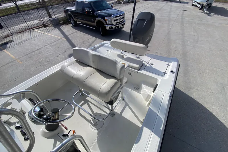 Slide: The Image of 2007 Triton 240 LTS boat interior with seating and steering wheel, parked near a black truck. - 19