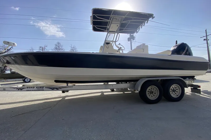 Slide: The Image of 2007 Triton 240 LTS boat on trailer, side view under clear sky. - 6