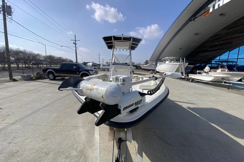 Slide: The Image of 2007 Triton 240 LTS boat with trolling motor, parked outdoors near a showroom. - 8