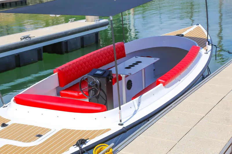 Slide: The Image of 2023 Vision Marine Technologies Fantail 217 boat with red seating, docked by the water. - 5