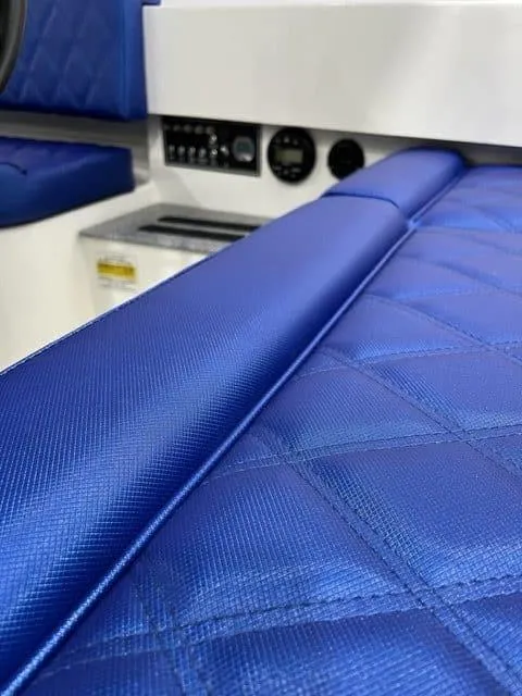 Slide: The Image of 2023 Vision Marine Technologies Fantail 217 interior with blue quilted seating and control panel. - 2