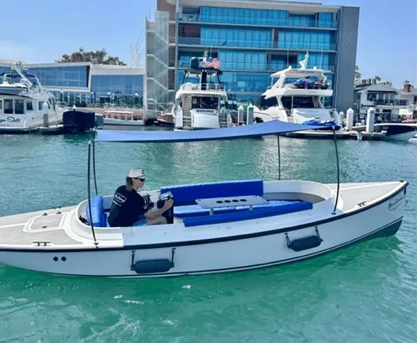 Slide: The Image of 2023 Vision Marine Technologies Fantail 217 boat on water, with blue canopy and seating. - 5