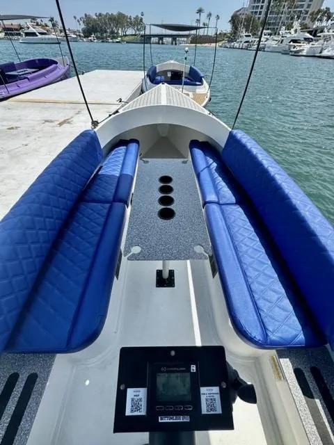 Slide: The Image of 2023 Vision Marine Technologies Fantail 217 boat with blue seating, docked by the water. - 7