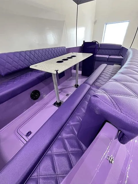 Slide: The Image of Luxurious purple interior of 2023 Vision Marine Fantail 217 boat with seating and table. - 2