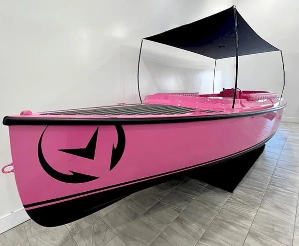 The Image of 2023 Vision Marine Technologies Fantail 217, pink electric boat with canopy, displayed indoors. - 0