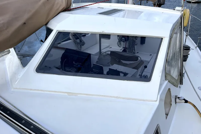 Slide: The Image of 1979 Amel Mango sailboat cockpit with navigation equipment and ropes visible through windows. - 14