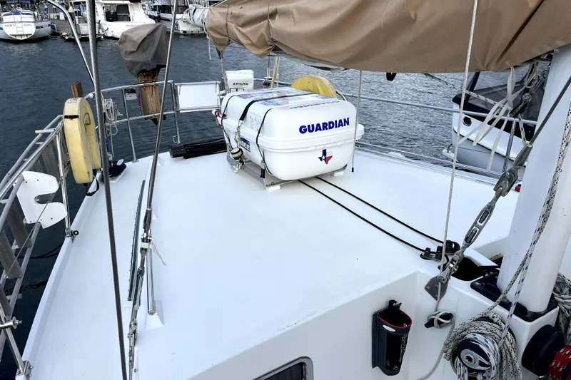 Slide: The Image of 1979 Amel Mango sailboat deck with lifeboat, docked in marina. - 21