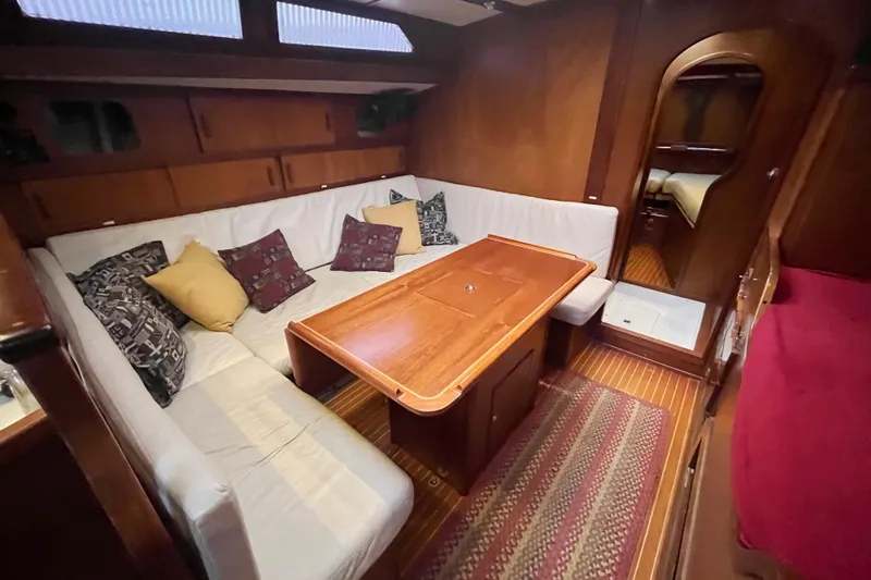 Slide: The Image of 1979 Amel Mango yacht interior with cozy seating and wooden table. - 28