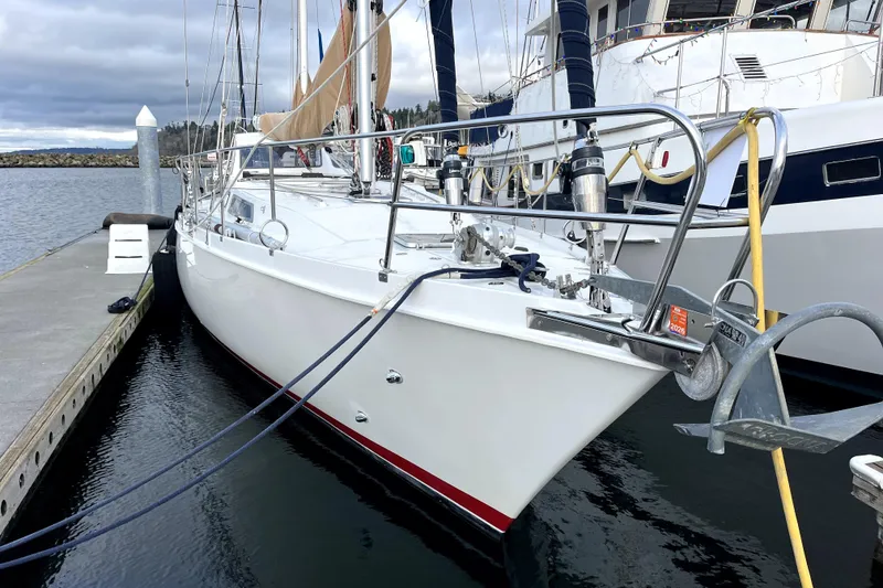 Slide: The Image of 1979 Amel Mango sailboat docked at marina, featuring sleek white hull and nautical equipment. - 3