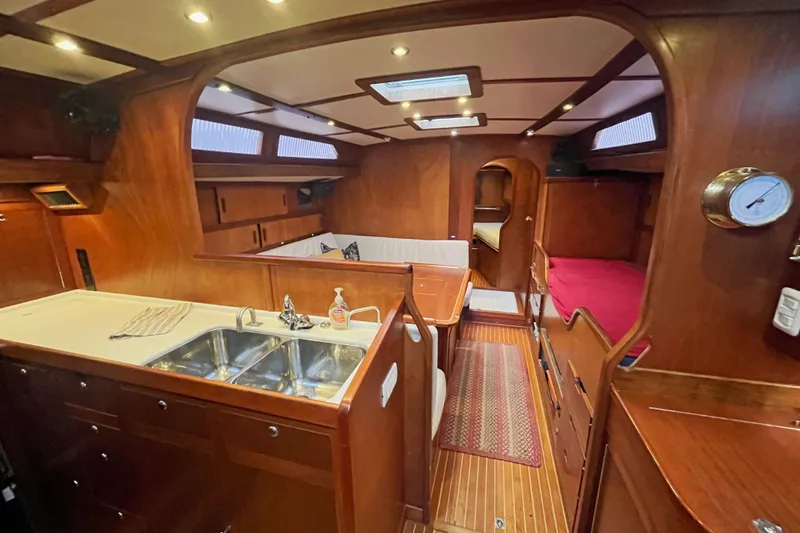 Slide: The Image of Interior of a 1979 Amel Mango sailboat with wooden finishes and cozy seating area. - 30