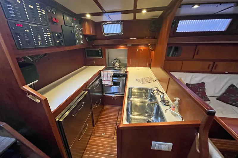 Slide: The Image of 1979 Amel Mango yacht interior with kitchen, featuring wood cabinetry and modern appliances. - 31