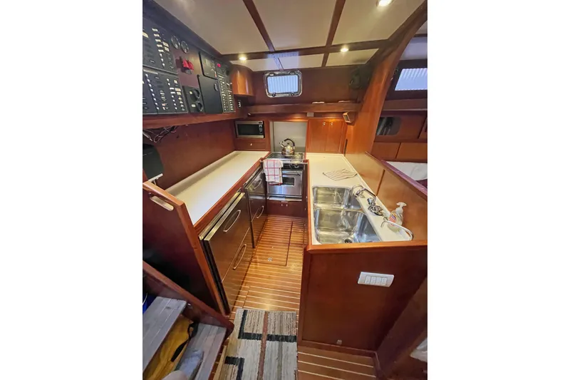 Slide: The Image of 1979 Amel Mango yacht kitchen with wood finish, dual sinks, and modern appliances. - 32