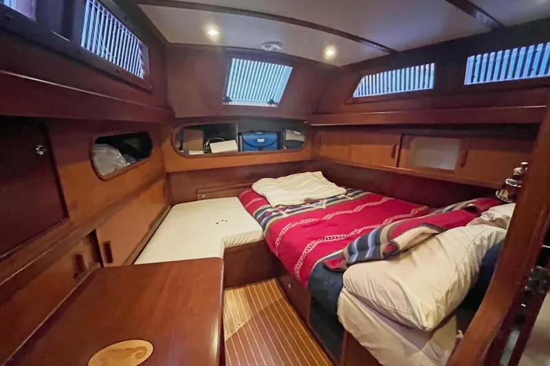 Slide: The Image of Cozy cabin interior of 1979 Amel Mango sailboat with wooden finish and bedding. - 39