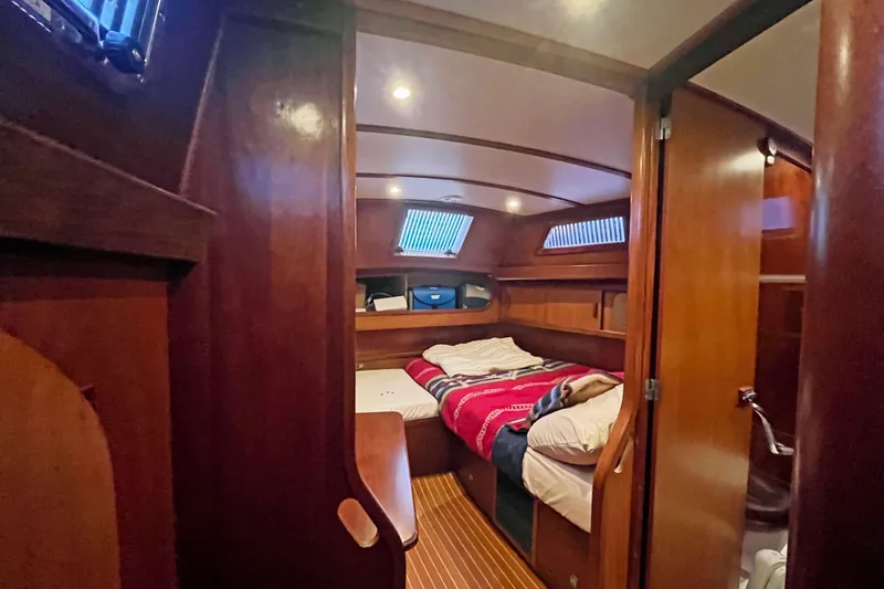 Slide: The Image of Cozy cabin interior of 1979 Amel Mango sailboat with wooden finish and bed. - 40