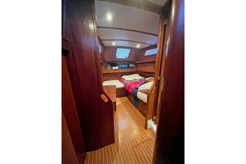 Slide: The Image of Interior of 1979 Amel Mango sailboat cabin with wooden finish and cozy bedding. - 41