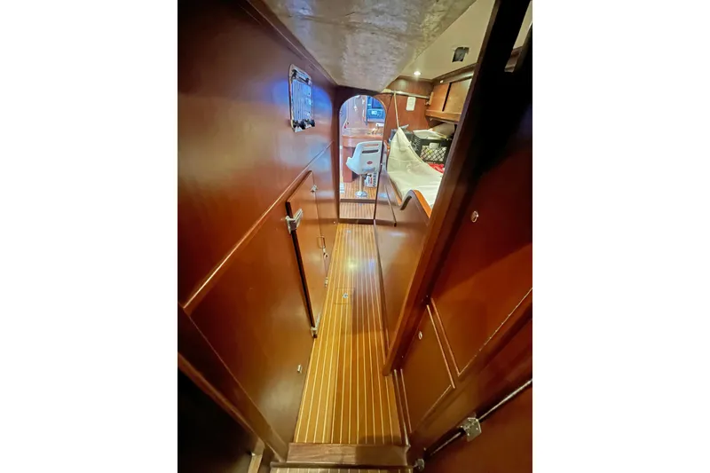 Slide: The Image of Interior of 1979 Amel Mango sailboat with wooden flooring and cozy cabin space. - 43