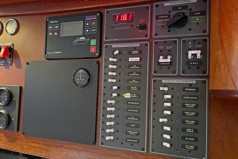 Slide: The Image of Electrical control panel on a 1979 Amel Mango boat, featuring various switches and gauges. - 47