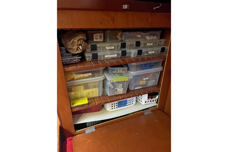 Slide: The Image of Organized storage cabinet with labeled plastic containers on a 1979 Amel Mango boat. - 49