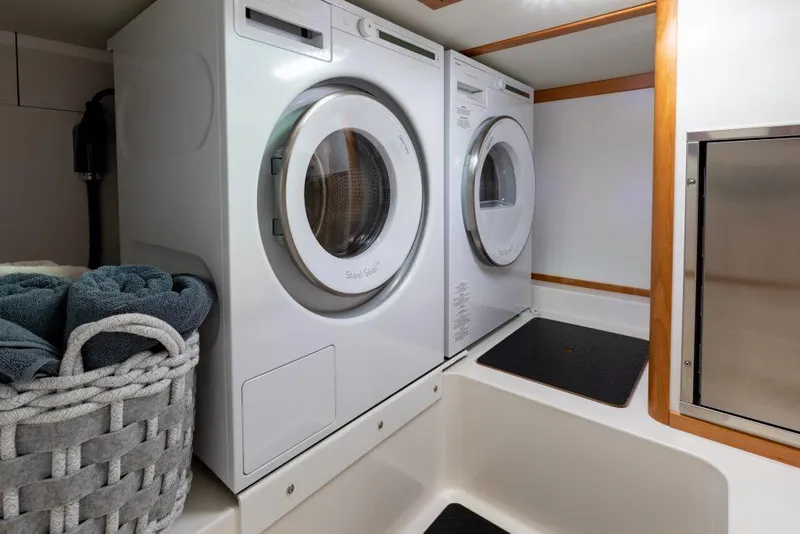 Slide: The Image of Laundry area in 2026 Sabre 43 Salon Express yacht with washer, dryer, and towels. - 33