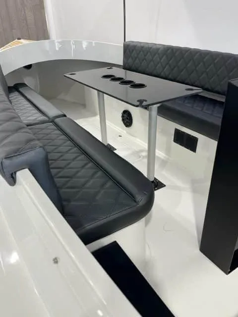 Slide: The Image of 2023 Vision Marine Technologies Fantail 217 interior with black quilted seating and sleek table design. - 2