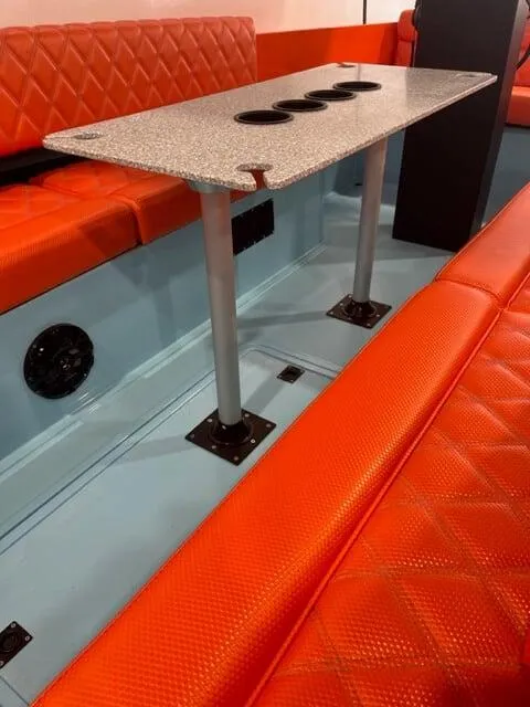 Slide: The Image of 2023 Vision Marine Fantail 217 interior with orange seating and a sleek table design. - 2