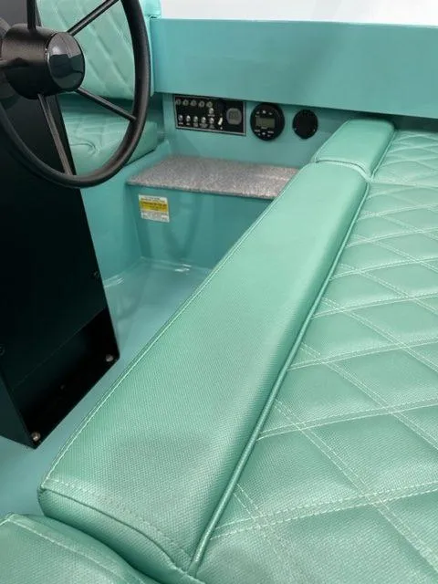Slide: The Image of 2023 Vision Marine Technologies Fantail 217 interior with teal quilted seating and steering wheel. - 4