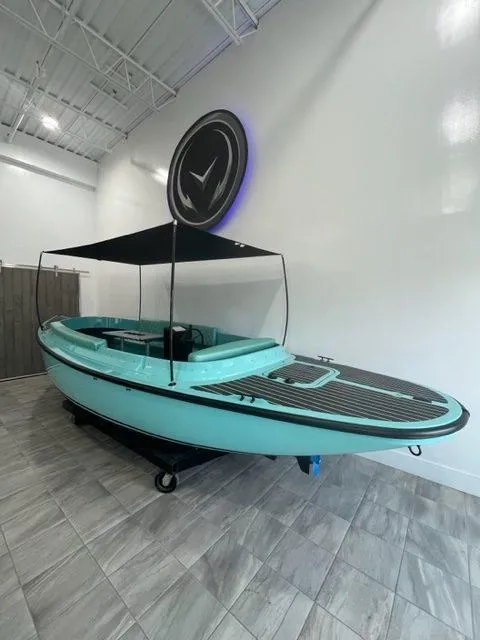 Slide: The Image of 2023 Vision Marine Technologies Fantail 217 boat in showroom, turquoise with canopy. - 6