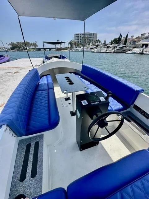 Slide: The Image of 2023 Vision Marine Technologies Fantail 217 boat with blue seating, docked at marina. - 6