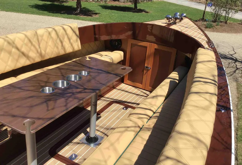 Slide: The Image of 2020 Vision Marine Technologies Fantail 217 boat interior with beige seating and wooden table. - 2