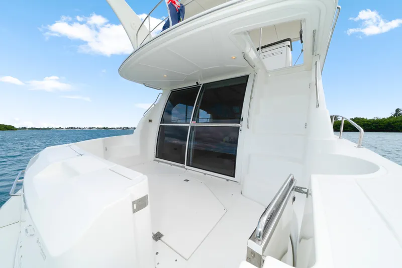 Slide: The Image of 2001 Cruisers Yachts 5000 Sedan Sport on water, showcasing spacious deck and sleek design. - 14