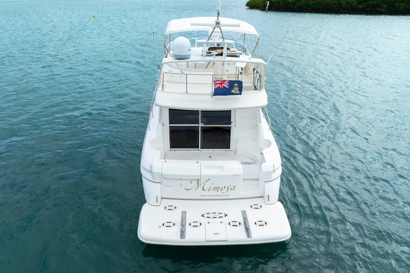 Slide: The Image of 2001 Cruisers Yachts 5000 Sedan Sport on calm blue water, rear view. - 8