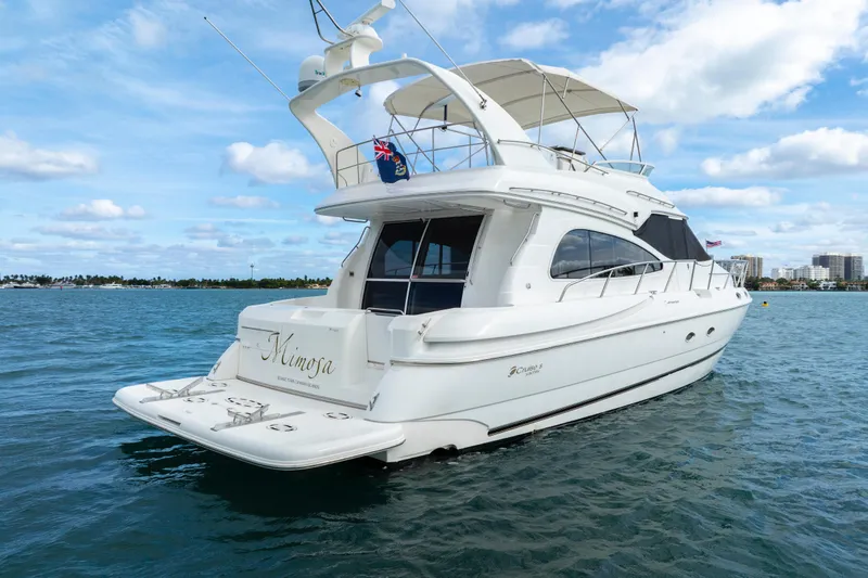 Slide: The Image of 2001 Cruisers Yachts 5000 Sedan Sport on calm blue water under a clear sky. - 9