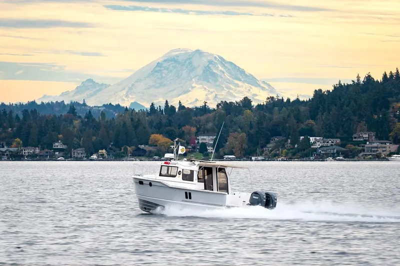Slide: The Image of 2026 Ranger Tugs R-27 cruising on a lake with a mountain backdrop. - 18