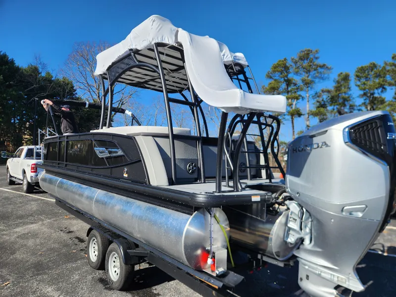 Slide: The Image of 2025 Godfrey AquaPatio Sundeck 275 SDC pontoon boat with Honda outboard motor on trailer. - 4