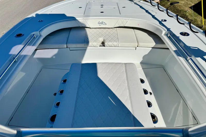 Slide: The Image of 2021 Costa Custom Boats 264 HC interior with cushioned seating and rod holders. - 15