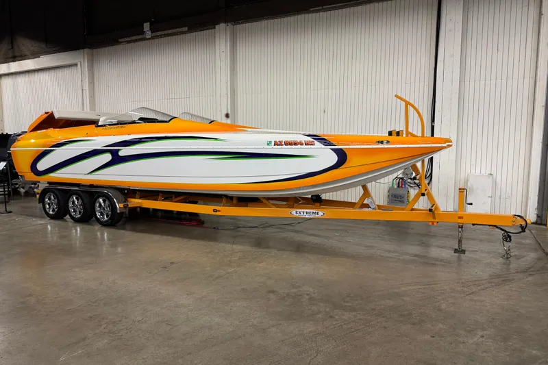 The Image of 2007 Eliminator Daytona 30 speedboat on trailer, vibrant orange and white design. - 1