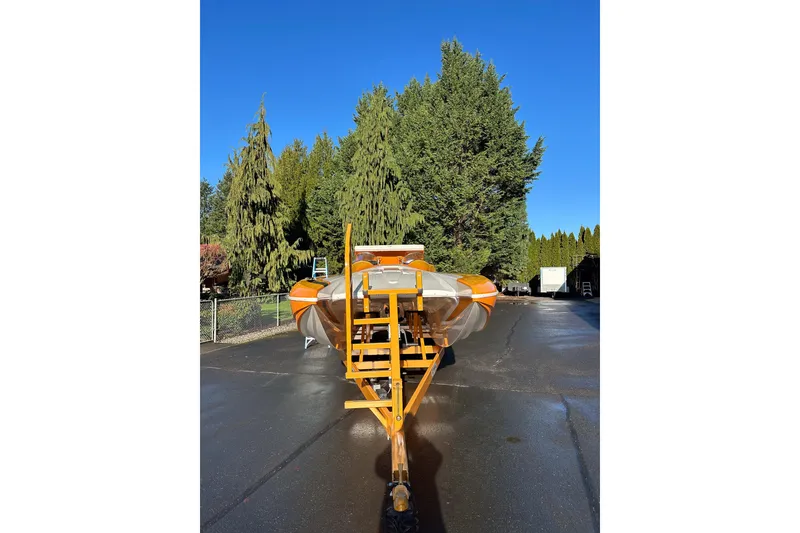 Slide: The Image of 2007 Eliminator Daytona 30 boat on trailer, surrounded by trees under clear blue sky. - 15