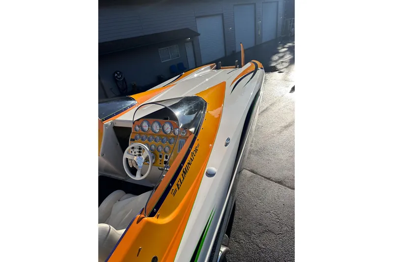 Slide: The Image of 2007 Eliminator Daytona 30 boat with vibrant orange and white design, detailed dashboard. - 18
