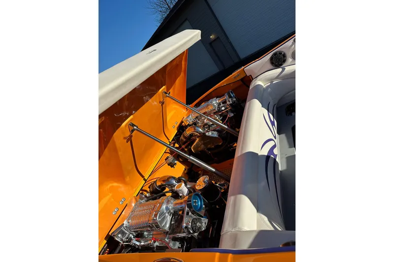 Slide: The Image of 2007 Eliminator Daytona 30 boat engine compartment with vibrant orange detailing. - 20