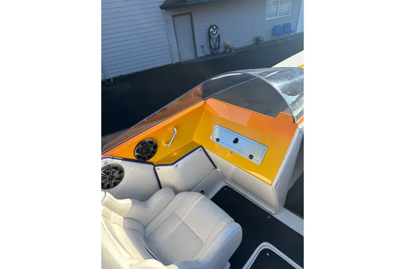 Slide: The Image of 2007 Eliminator Daytona 30 boat interior with white seats and vibrant orange dashboard. - 21