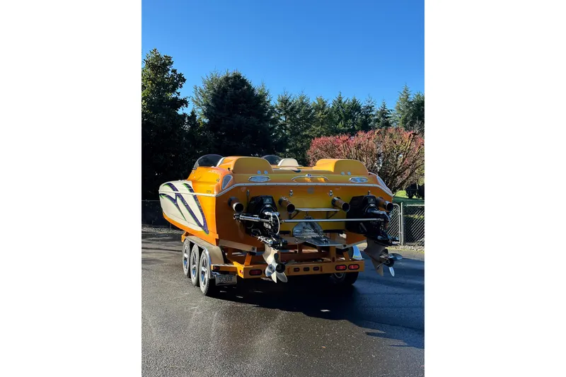 Slide: The Image of 2007 Eliminator Daytona 30 powerboat, vibrant yellow, parked outdoors on a trailer. - 3