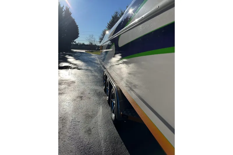 Slide: The Image of 2007 Eliminator Daytona 30 boat on trailer, side view with sunlight reflections. - 37