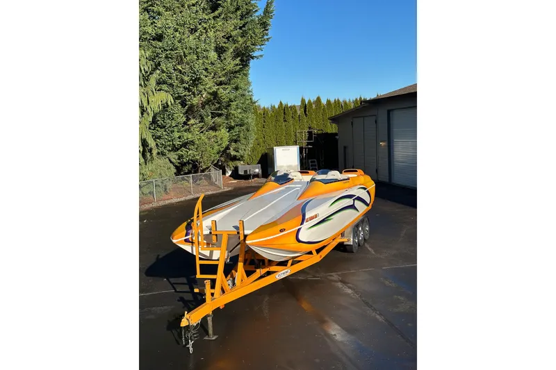 Slide: The Image of 2007 Eliminator Daytona 30 boat with vibrant orange and white design on a trailer. - 4