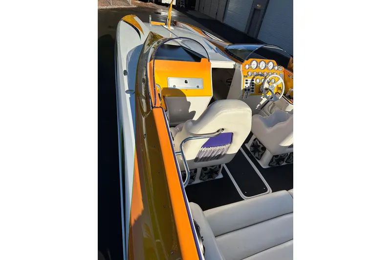 Slide: The Image of 2007 Eliminator Daytona 30 boat interior with orange accents and detailed dashboard. - 40