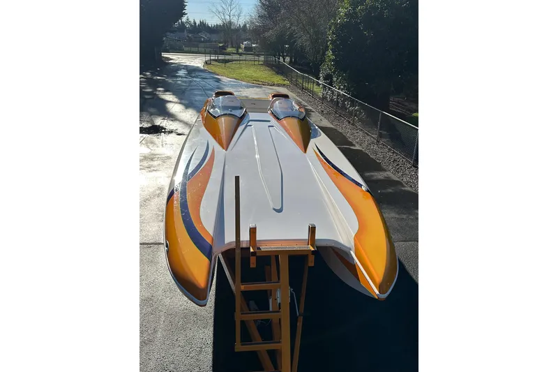 Slide: The Image of 2007 Eliminator Daytona 30 powerboat with vibrant orange and blue accents, parked outdoors. - 44