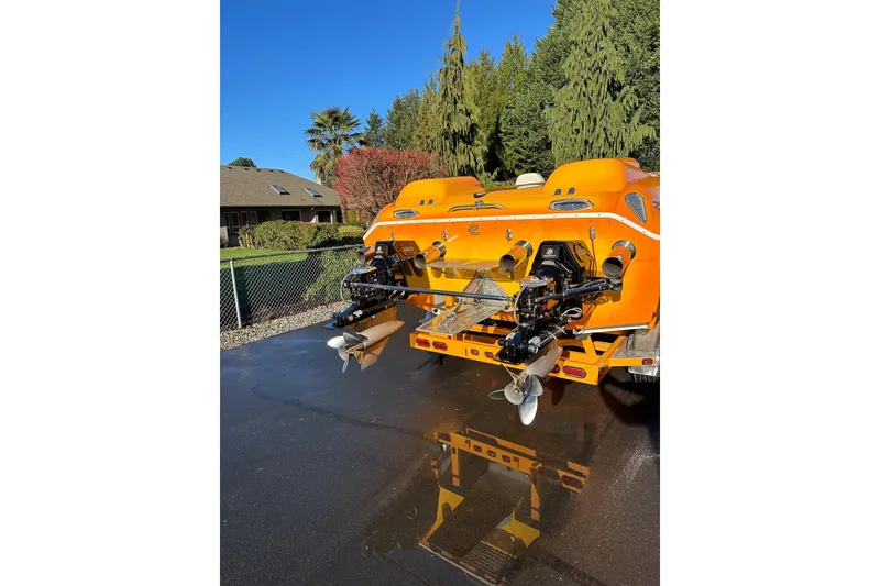 Slide: The Image of 2007 Eliminator Daytona 30 boat, vibrant orange, rear view with dual propellers. - 49