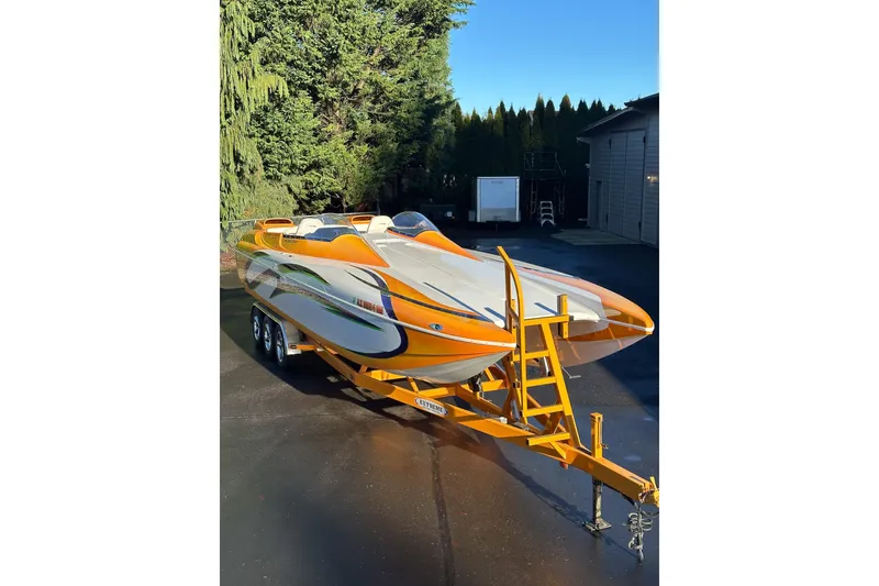Slide: The Image of 2007 Eliminator Daytona 30 speedboat with vibrant orange and white design on a trailer. - 53